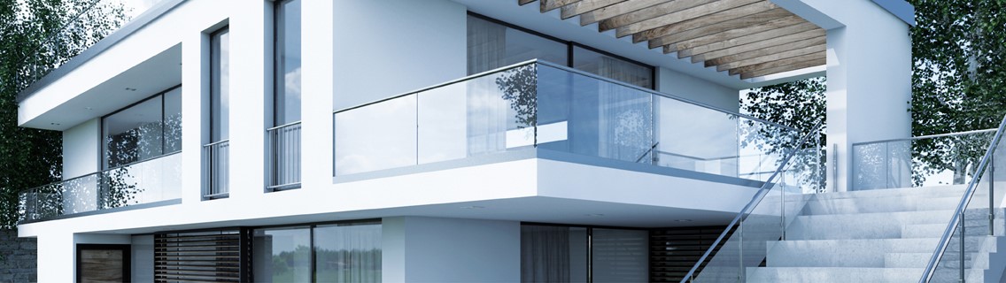 Ganzglasgeländer montiert am Balkon einer schönen Stadtvilla mit weißer Fassade